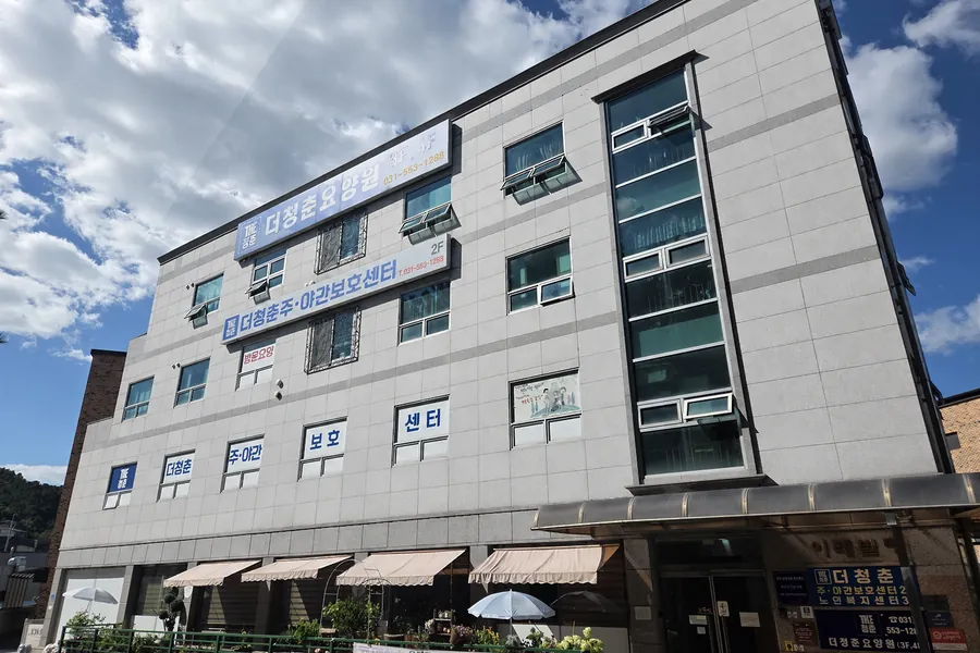 길 건너에서 본 건물 전체. 오른쪽 입구 기둥에 주야간보호센터 2층, 노인복지센터 3층, 요양원 3·4층 안내가 붙어 있습니다.